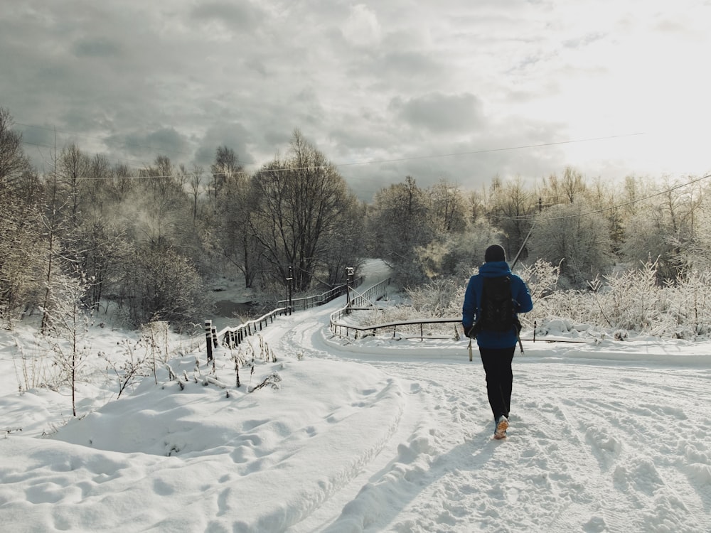 a person walking down a snow covered road