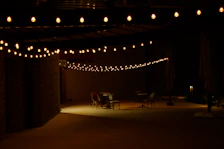 Outdoor patio with string lights and picnic tables styled with 90s themed tablecloths.