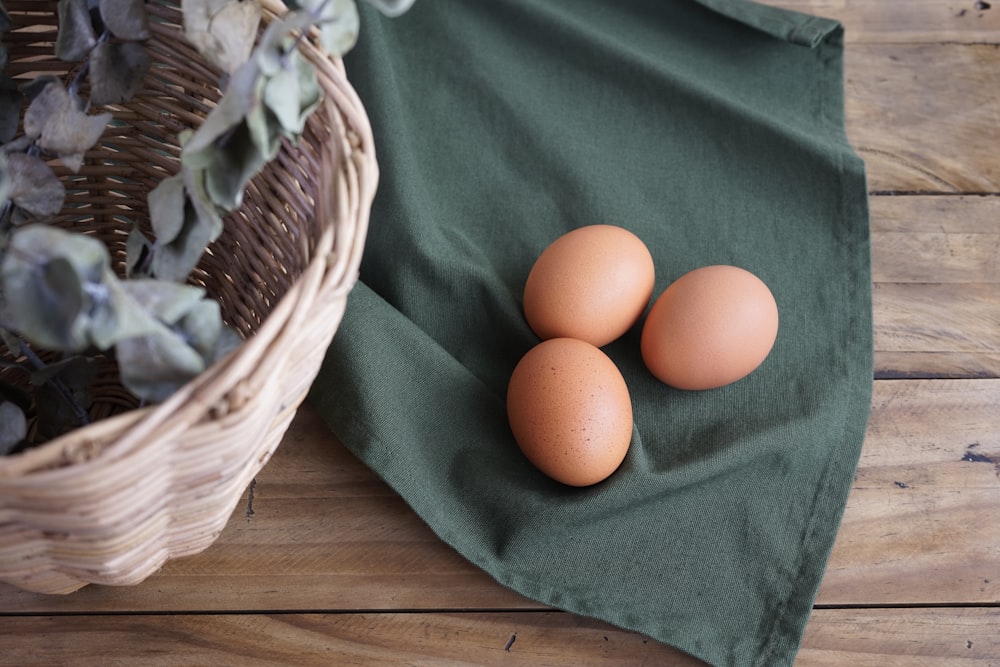 three eggs in a basket on a table