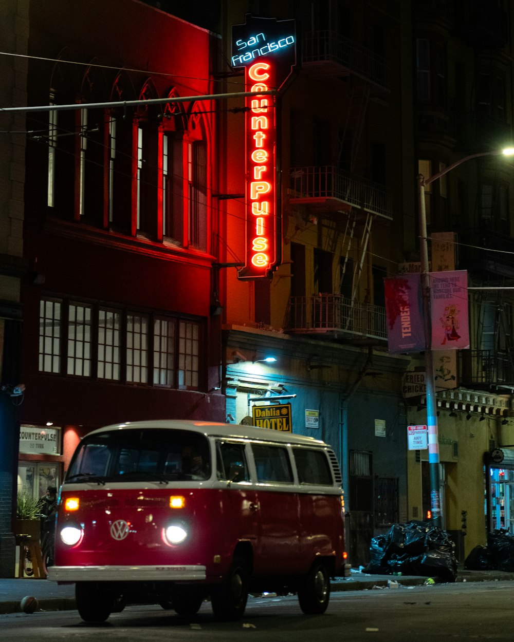 a van is driving down a city street at night