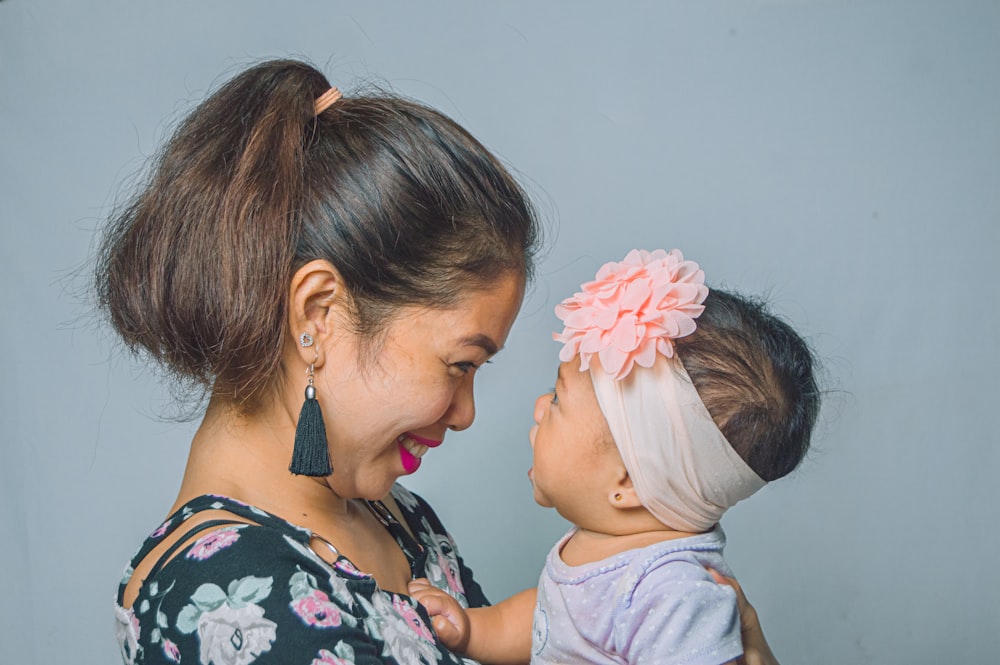 a woman holding a baby and smiling at each other