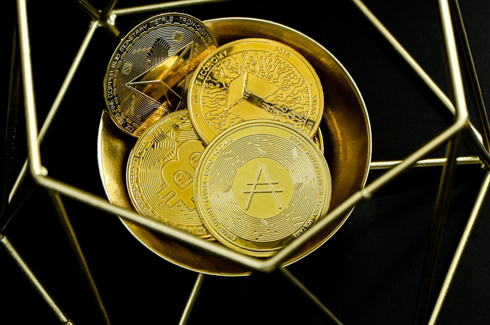 a bowl of gold and silver coins on a black background
