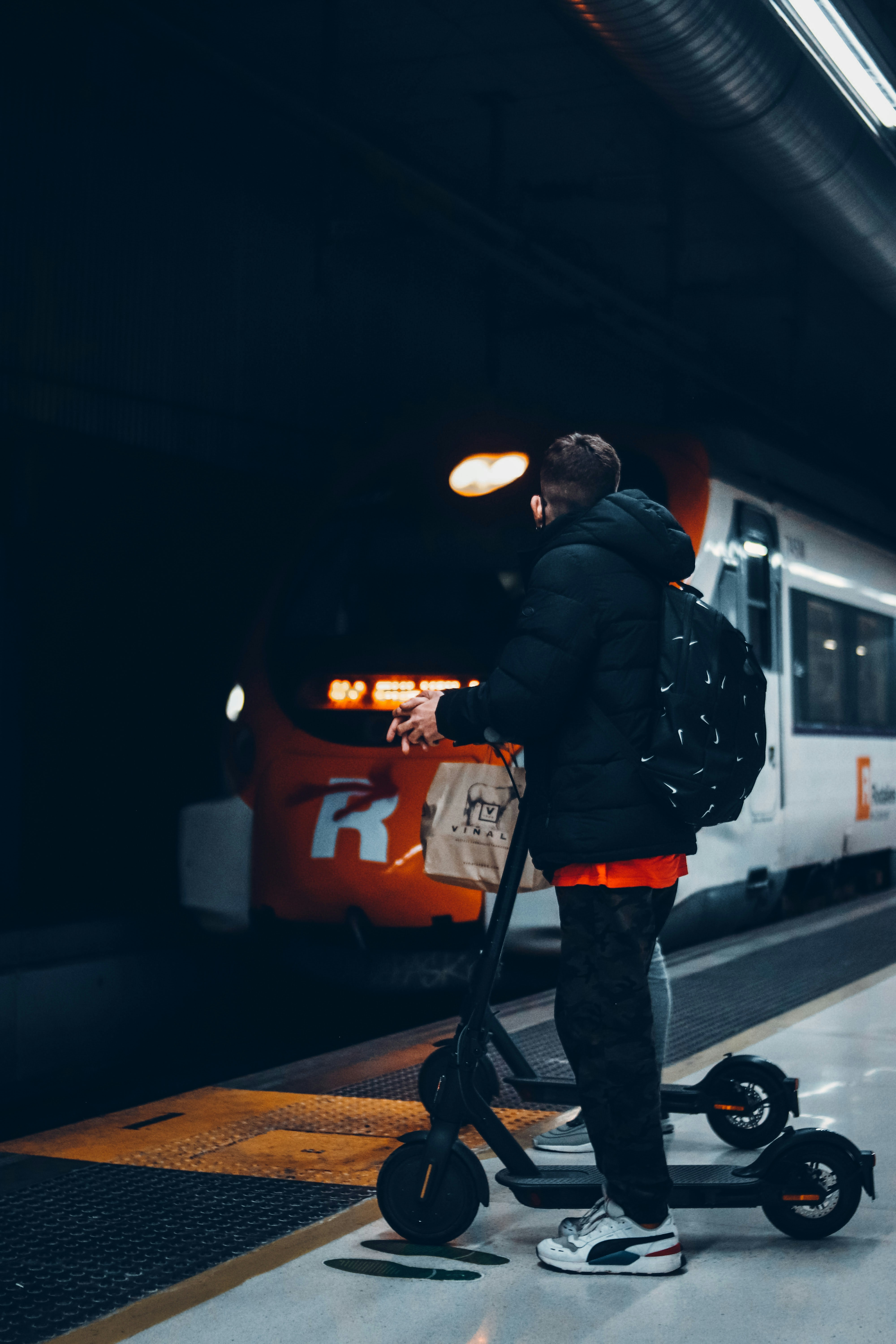 a man standing on a scooter in a subway station