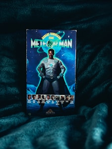 A movie poster with a science fiction theme featuring a superhero character in metallic armor standing with a confident pose. The background includes planetary and cosmic imagery. There are multiple smaller images of cast members along the bottom.