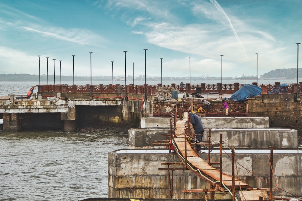 a man walking across a bridge over a body of water