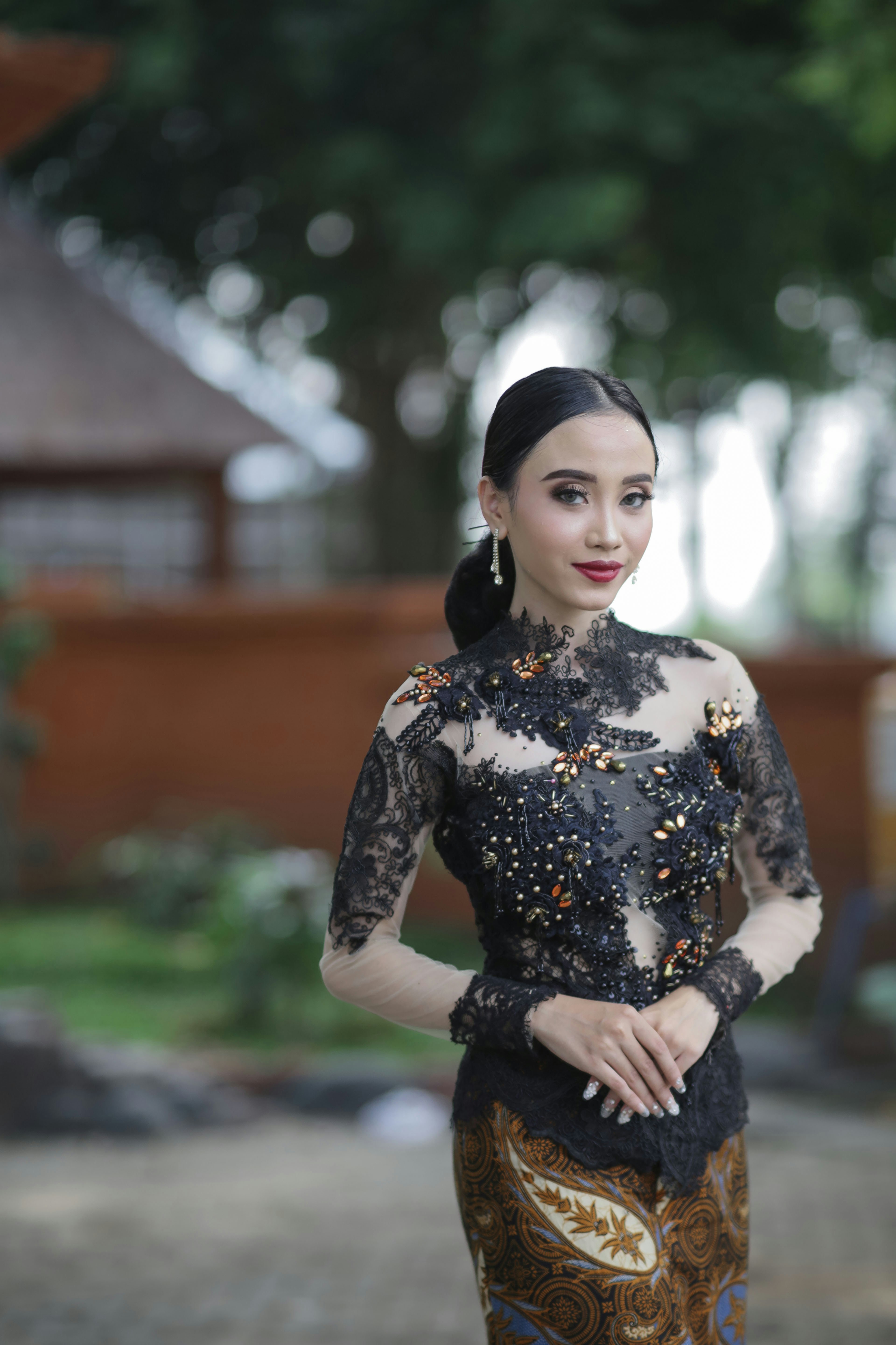 seorang wanita dengan gaun hitam dan emas berpose untuk foto