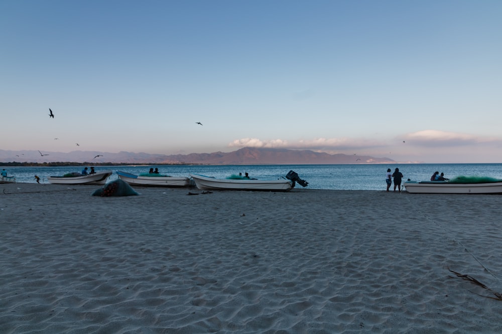 a group of boats sitting on top of a sandy beach