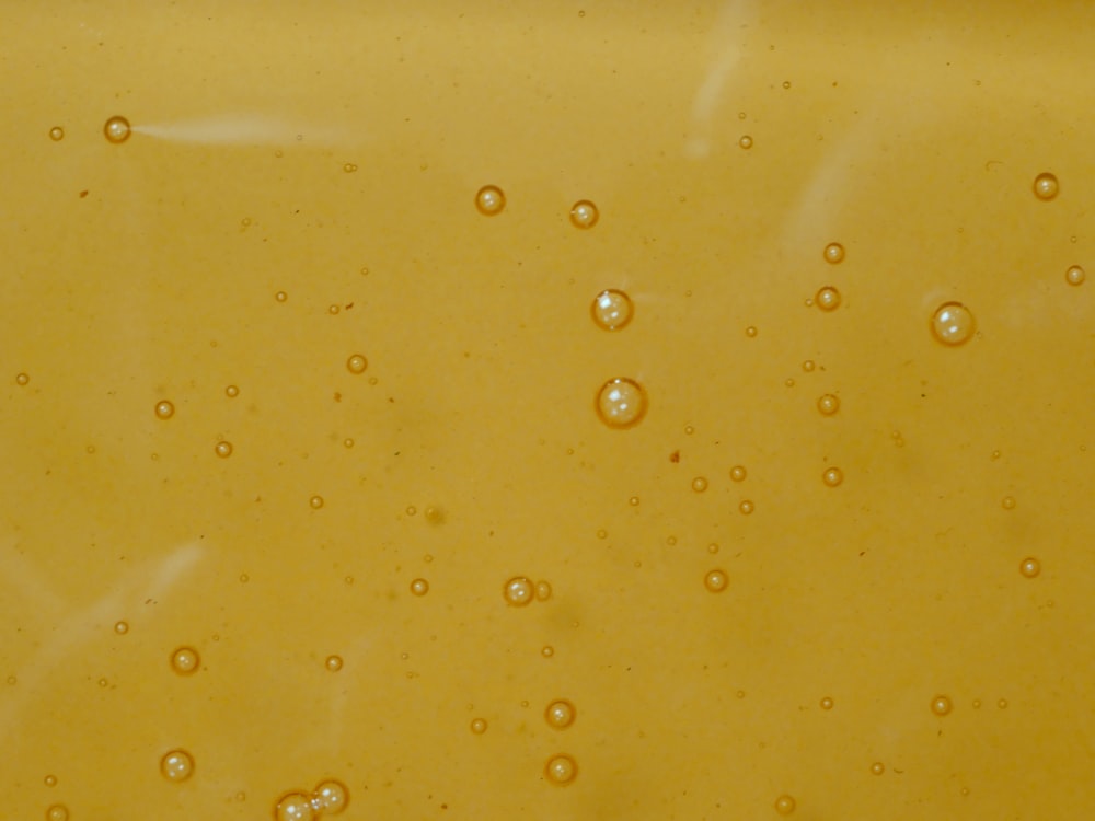 a close up of water bubbles on a yellow surface