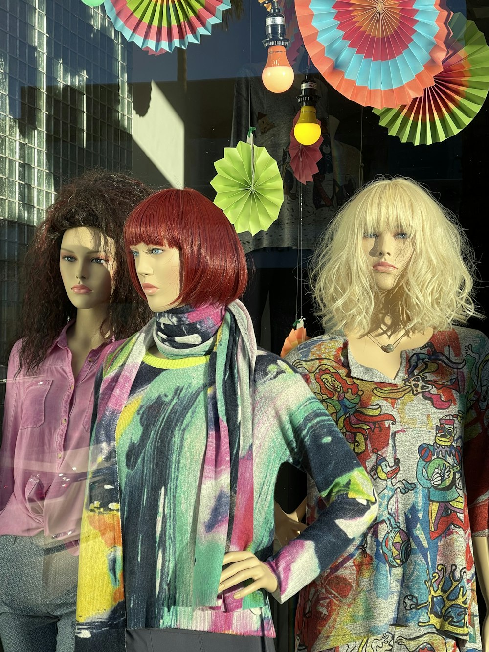 a group of mannequins that are standing in front of a window