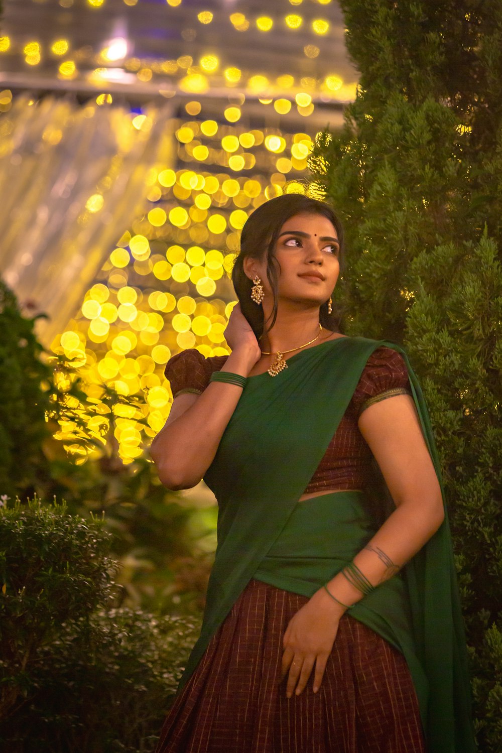 a woman in a green and brown dress talking on a cell phone