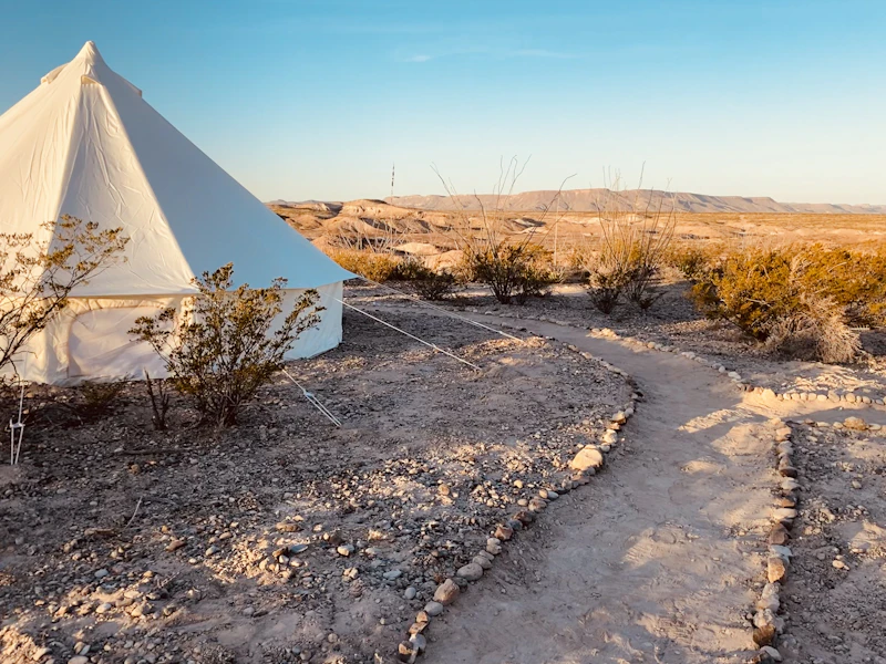 White bell tent rocky desert golden hour Agafay