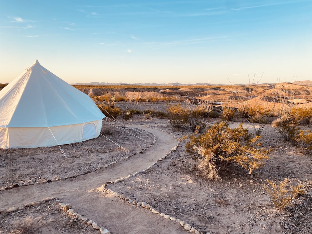 a white tent in the middle of a desert