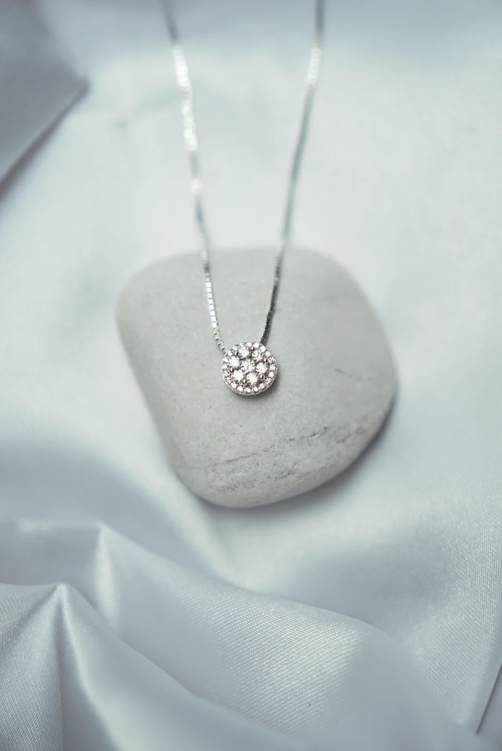 a white rock with a silver necklace on it