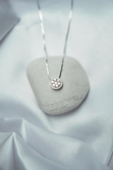 a white rock with a silver necklace on it