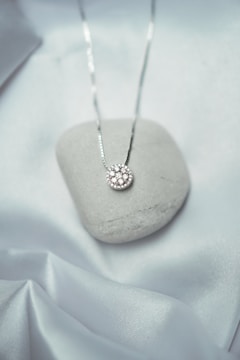 a white rock with a silver necklace on it