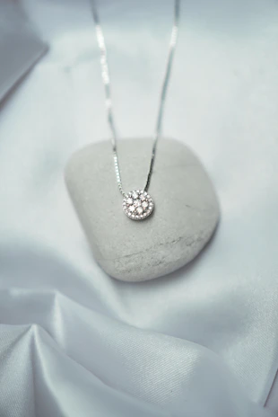 a white rock with a silver necklace on it