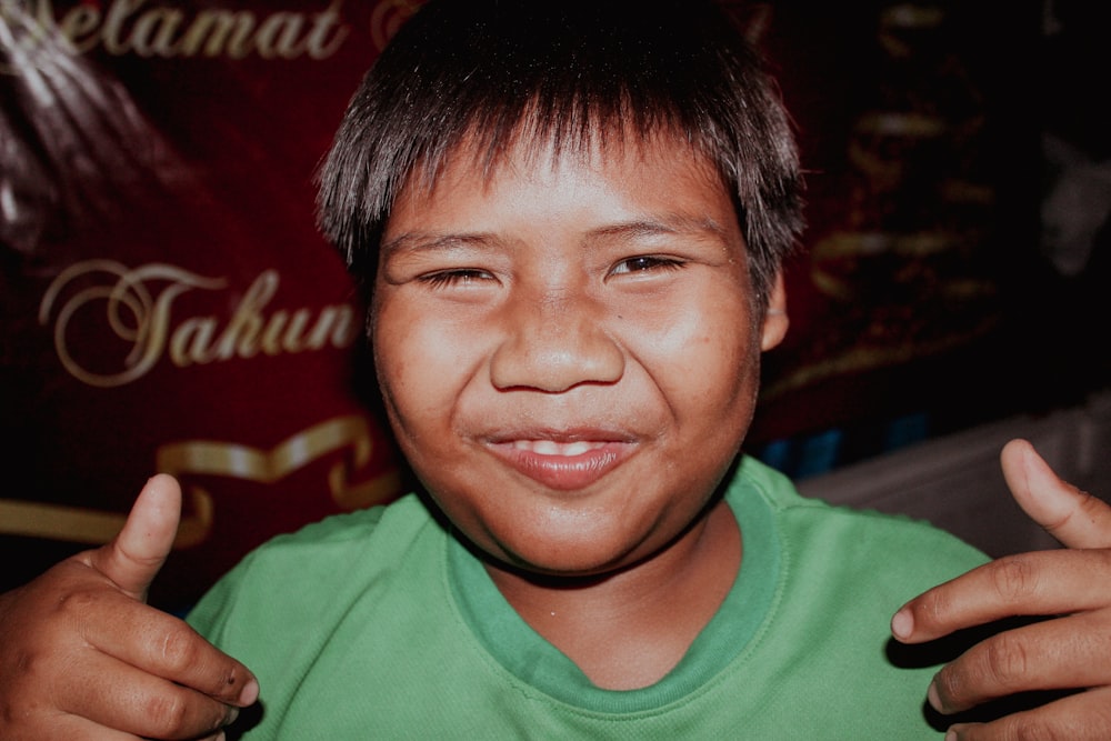 a young boy giving the thumbs up sign