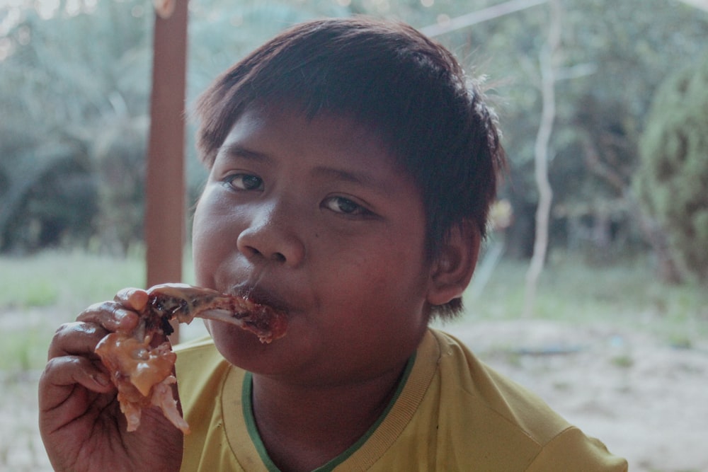a young boy eating a piece of pizza