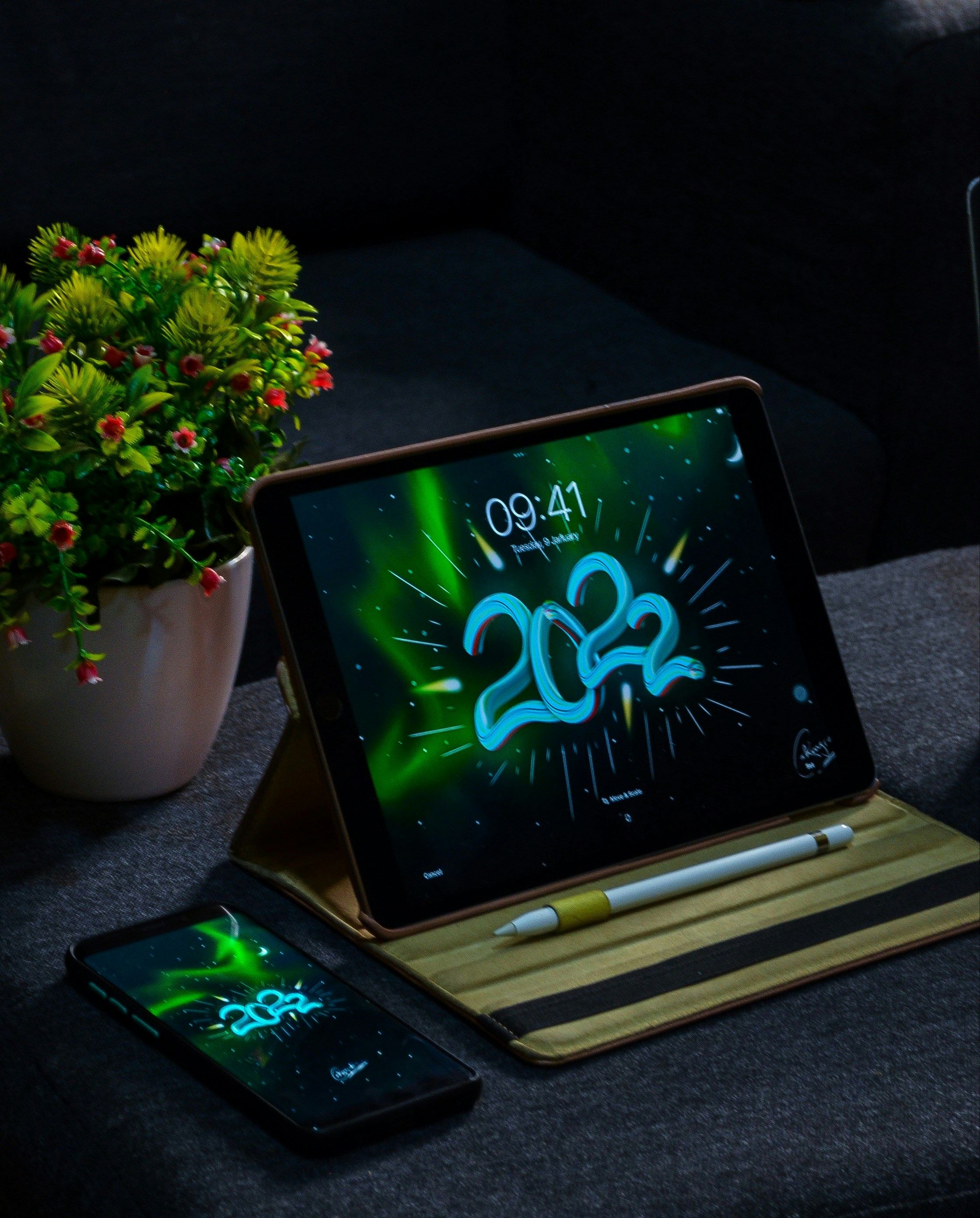 a tablet computer sitting on top of a table next to a plant