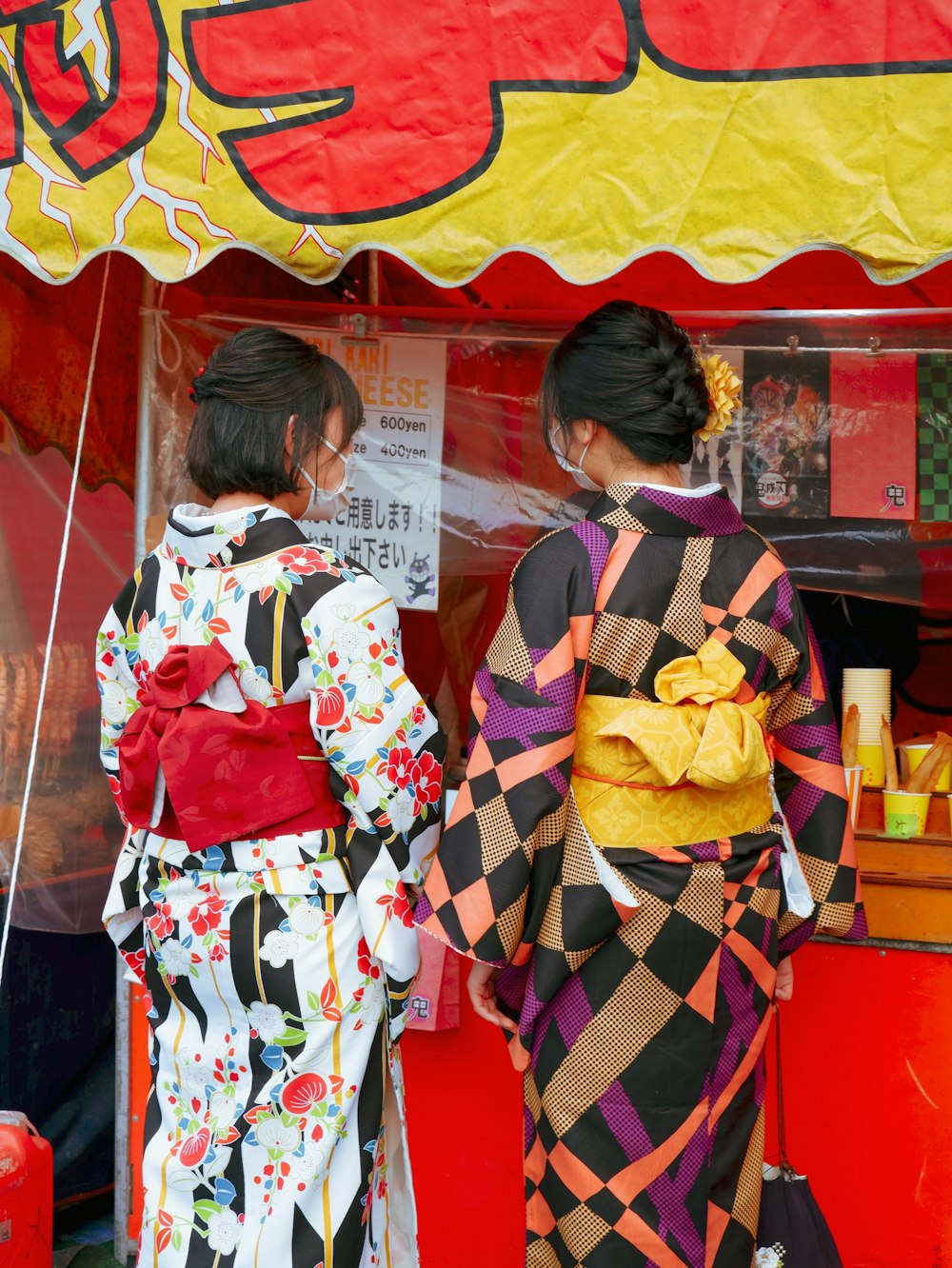 a couple of women standing next to each other under a tent