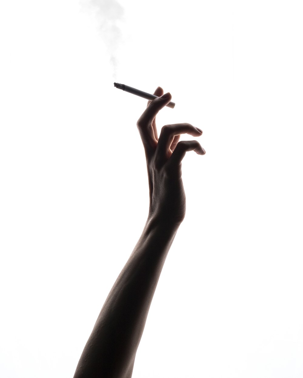 a person holding a cigarette in their hand
