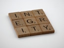 a scrabbled wooden block with the words integr city on it