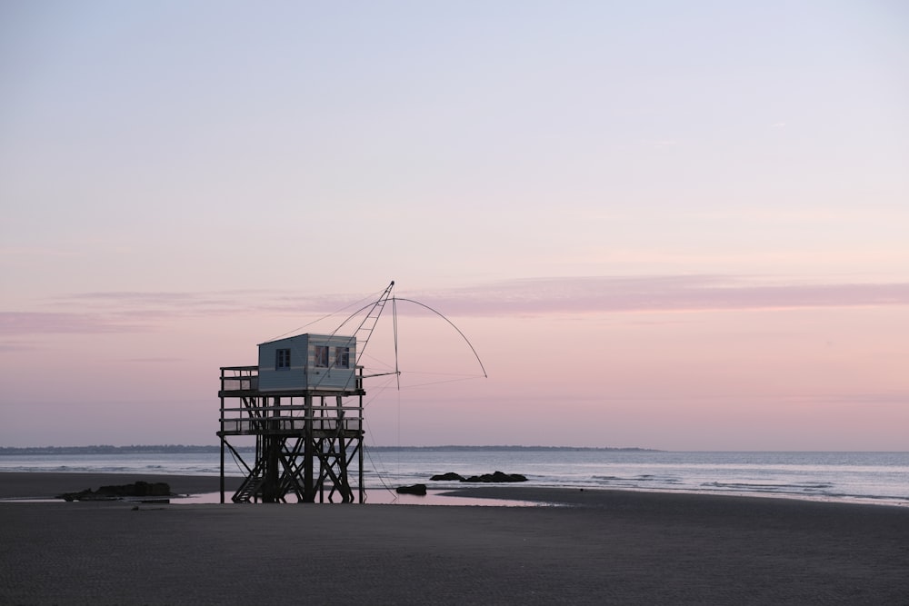 a lifeguard tower sitting on top of a sandy beach