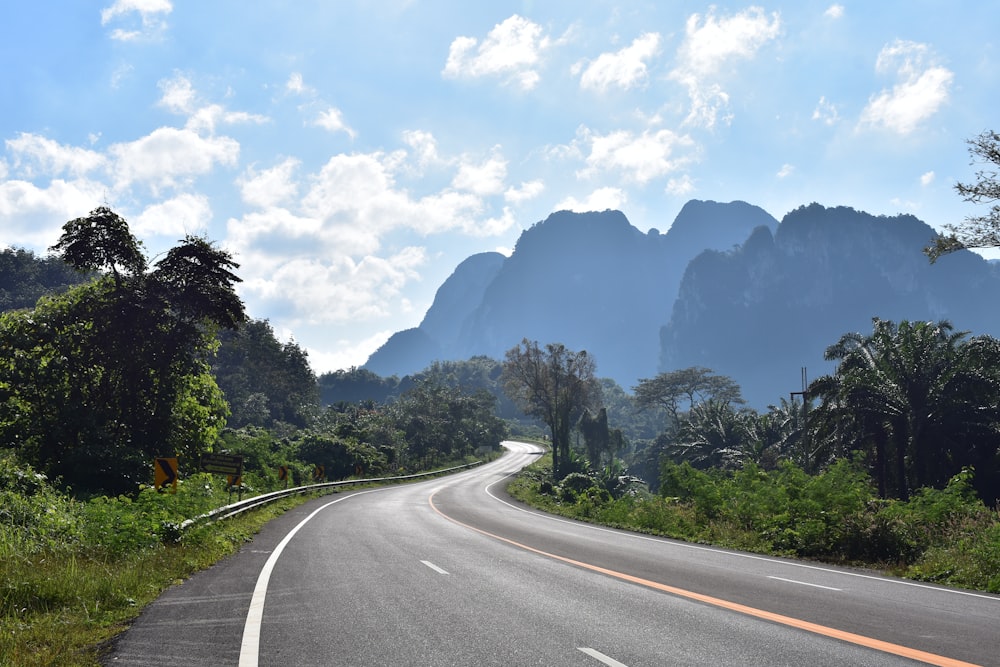 uma estrada curva com montanhas ao fundo