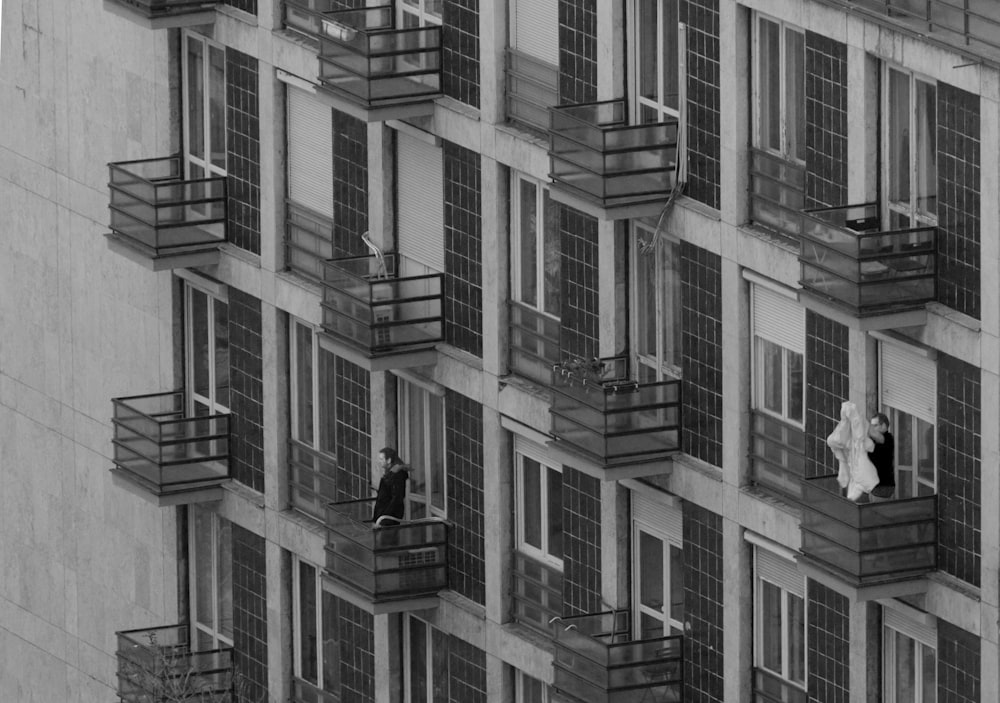 a couple of people that are standing in the windows of a building