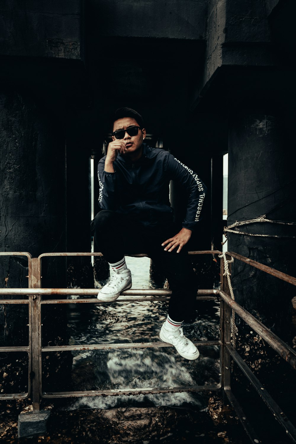 a man sitting on top of a metal rail