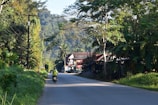 Rolling hills and a narrow road in the French countryside with a motorbike in motion.