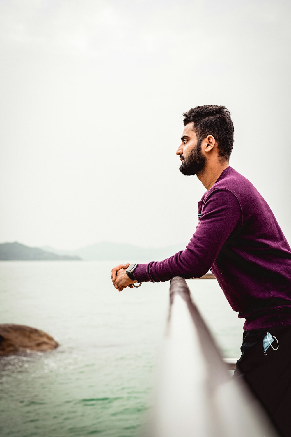 a man standing on a bridge looking at the water