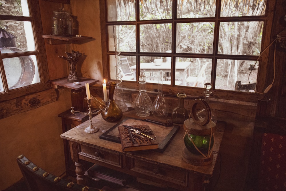 uma mesa de madeira coberta com uma garrafa de vinho ao lado de uma janela