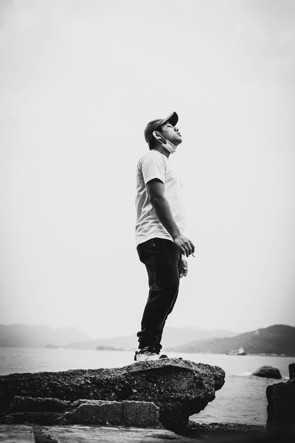 a man standing on top of a rock near the ocean