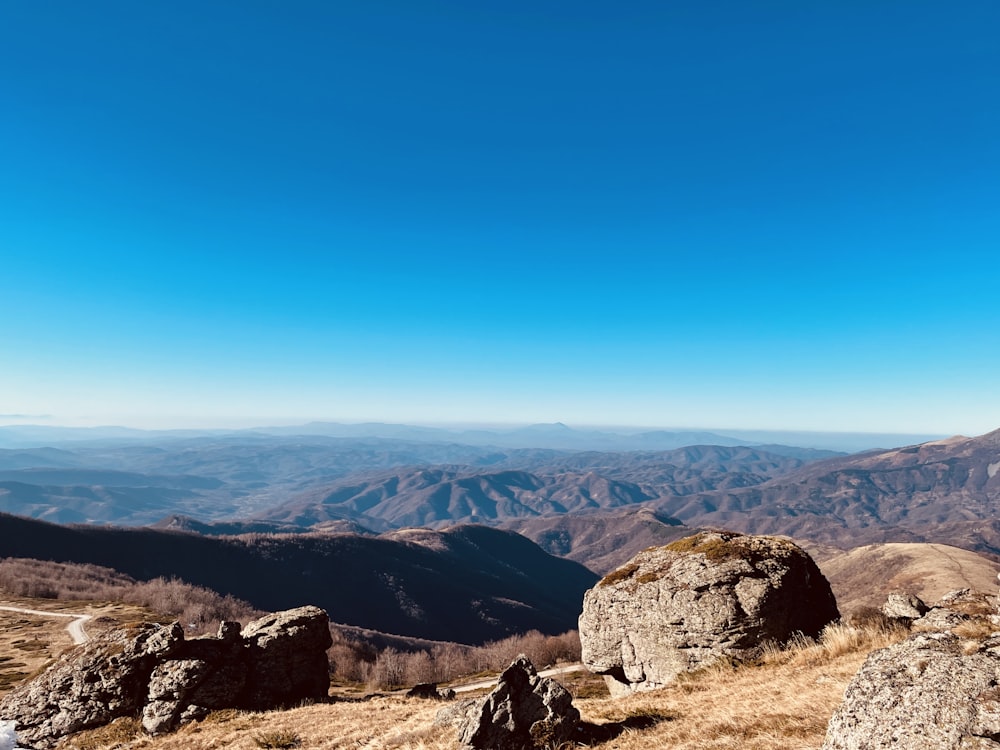 a view of a mountain range from the top of a hill