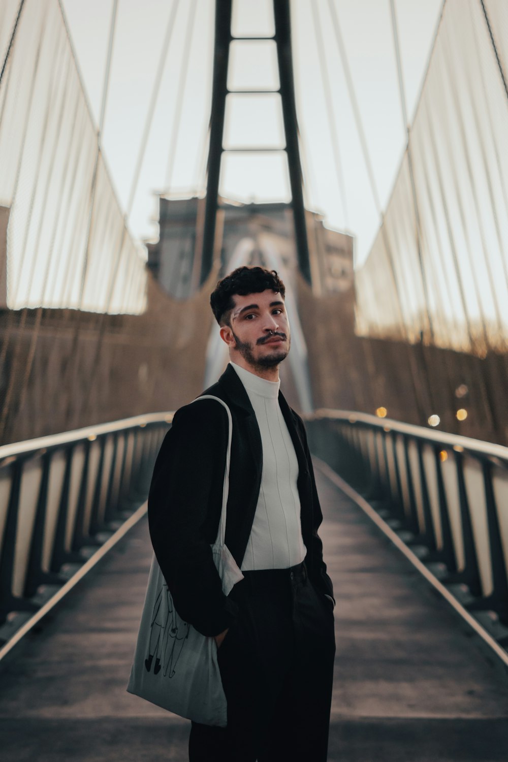 a man standing on a bridge with a handbag