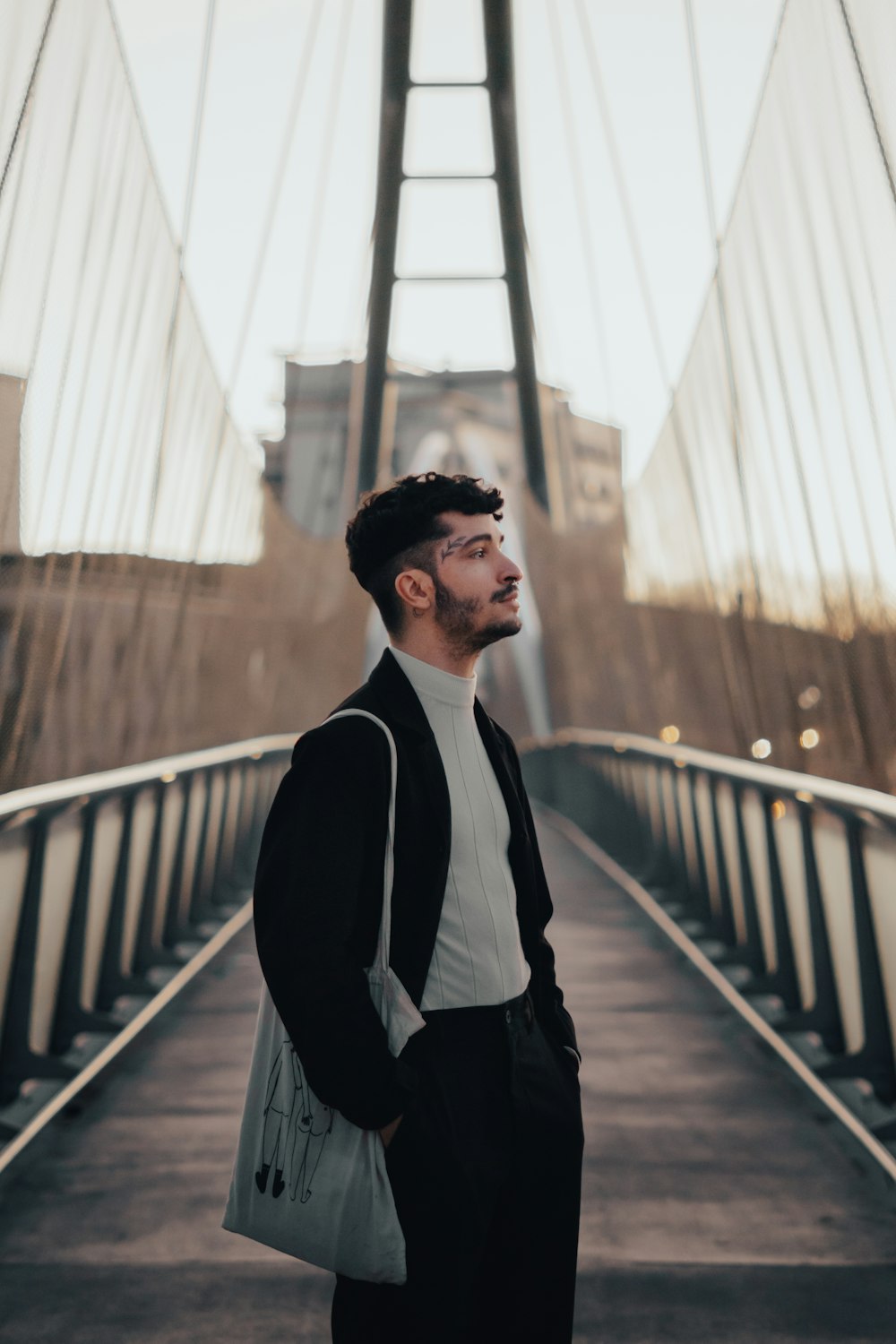 a man standing on a bridge with a handbag