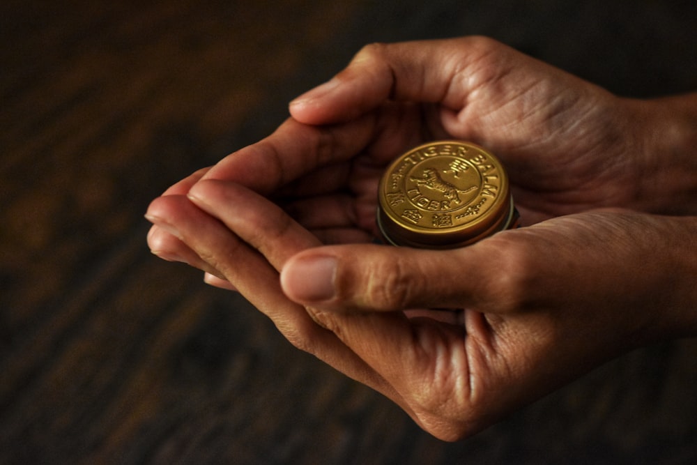 a person holding a gold coin in their hands