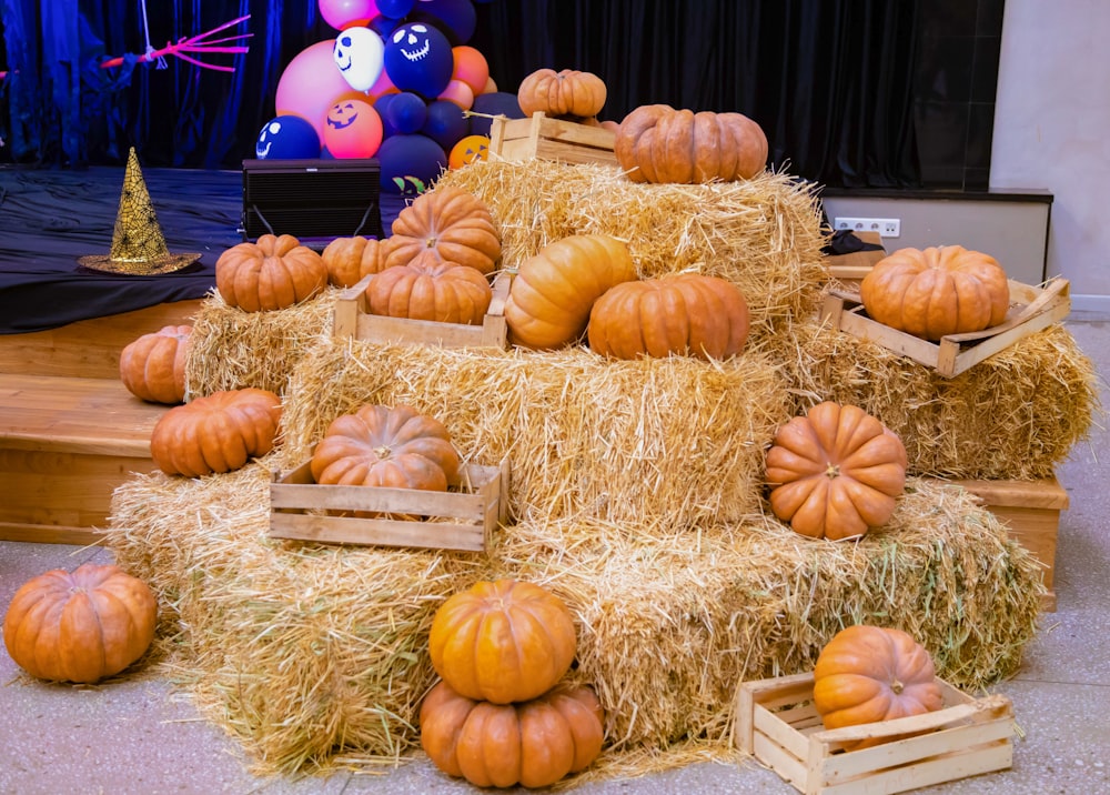 a pile of hay with pumpkins on top of it