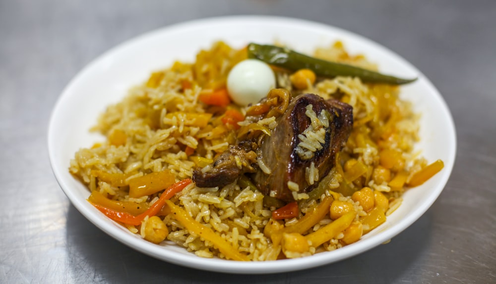 a white bowl filled with rice and vegetables