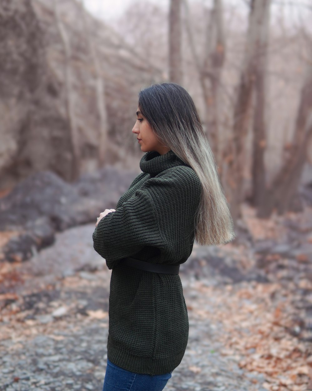 a woman with grey hair standing in a forest