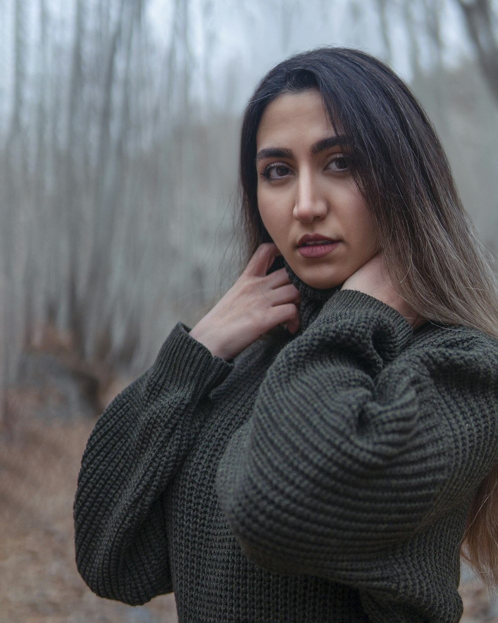 a woman in a green sweater posing for a picture