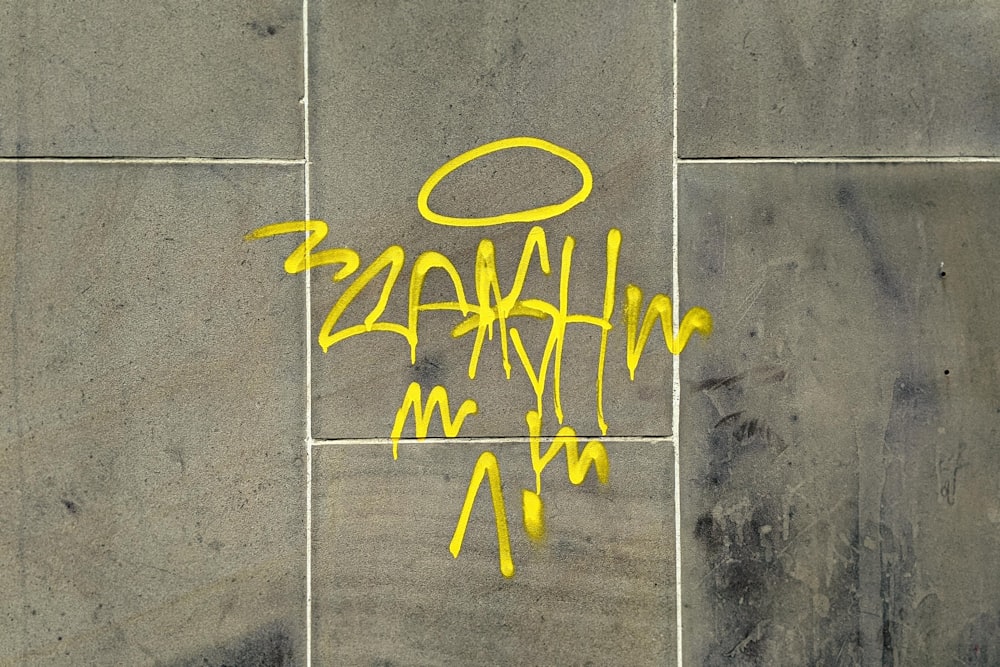 a picture of a wall with yellow graffiti on it