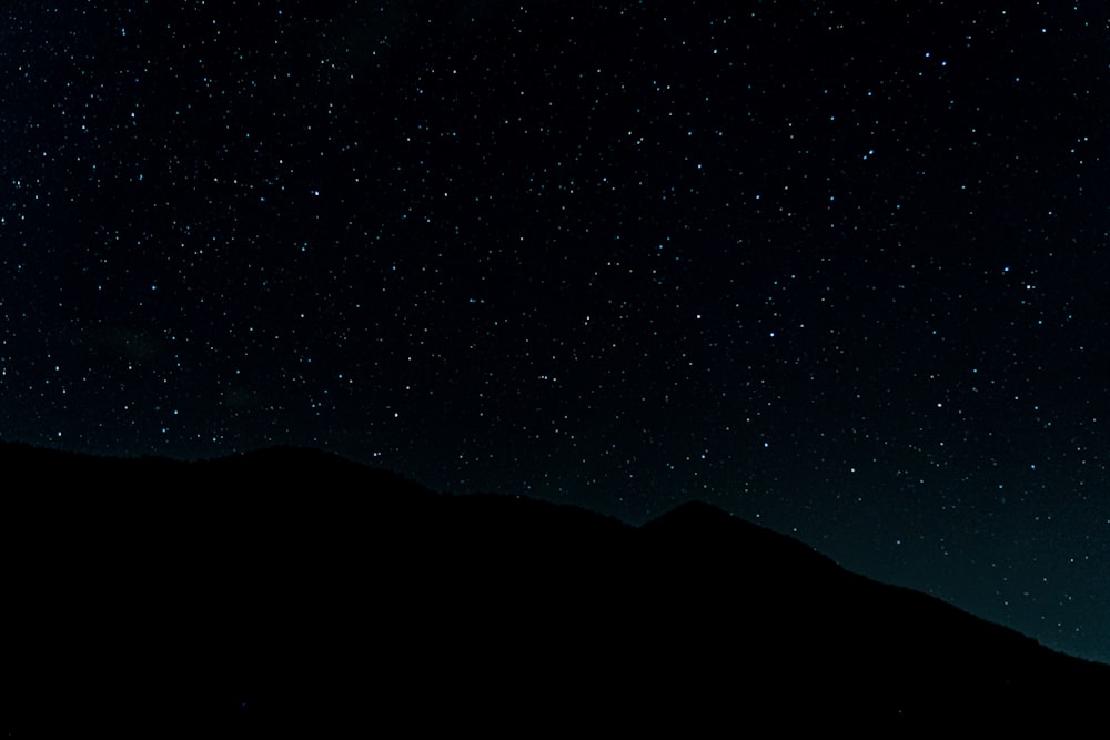 the night sky is full of stars above a mountain