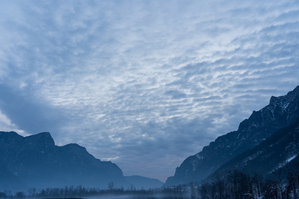 a view of a mountain range with clouds in the sky