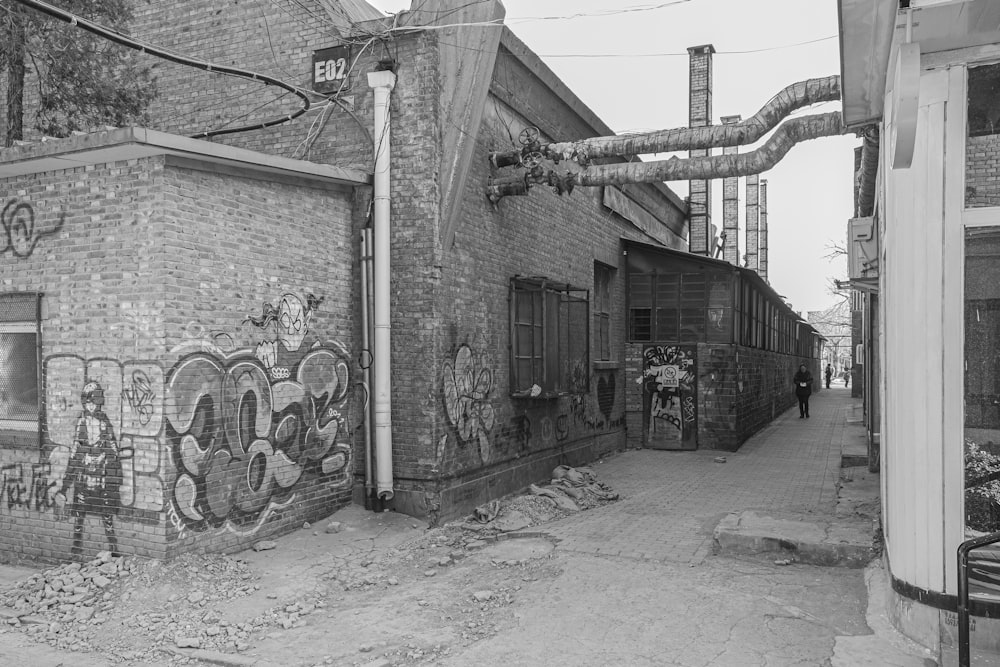 a black and white photo of a brick building with graffiti on it