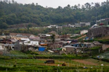 Surveyors gathering data in a rural Indian village with traditional homes in the background.