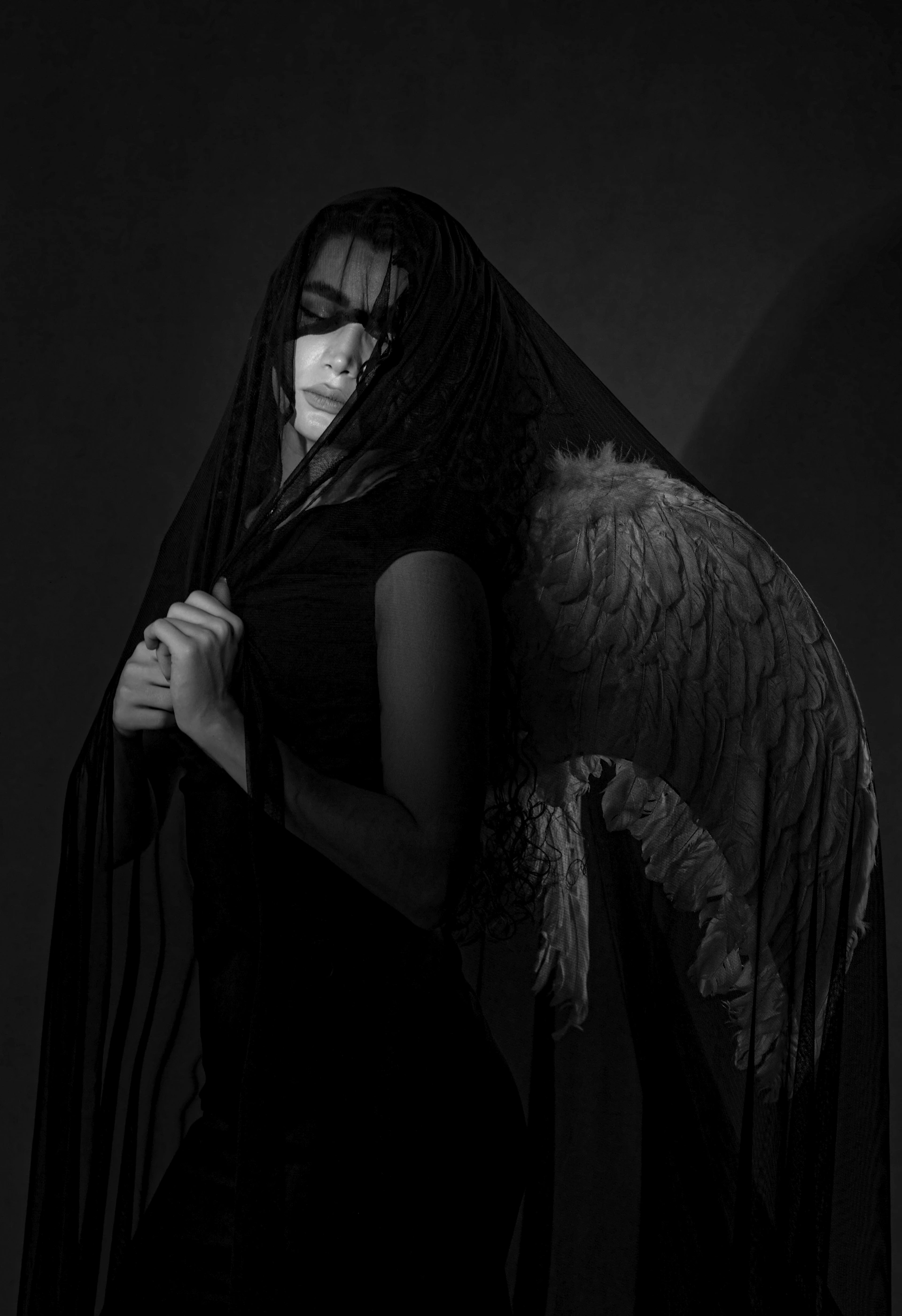 a black and white photo of a woman with angel wings