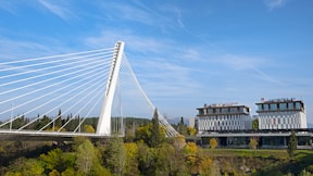 a large white bridge over a river next to a tall building