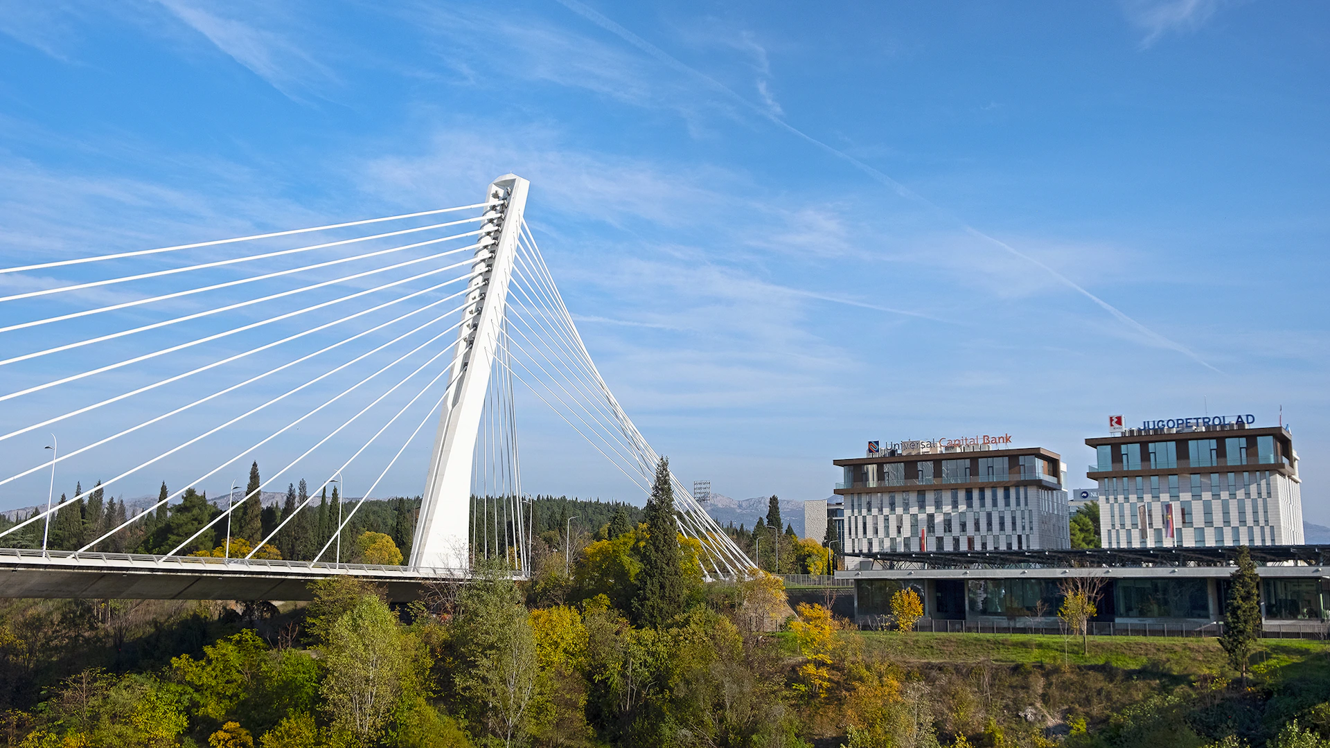 a large white bridge over a river next to a tall building
